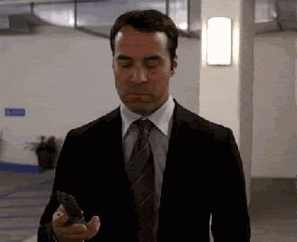 man in suit checking phone annoyed