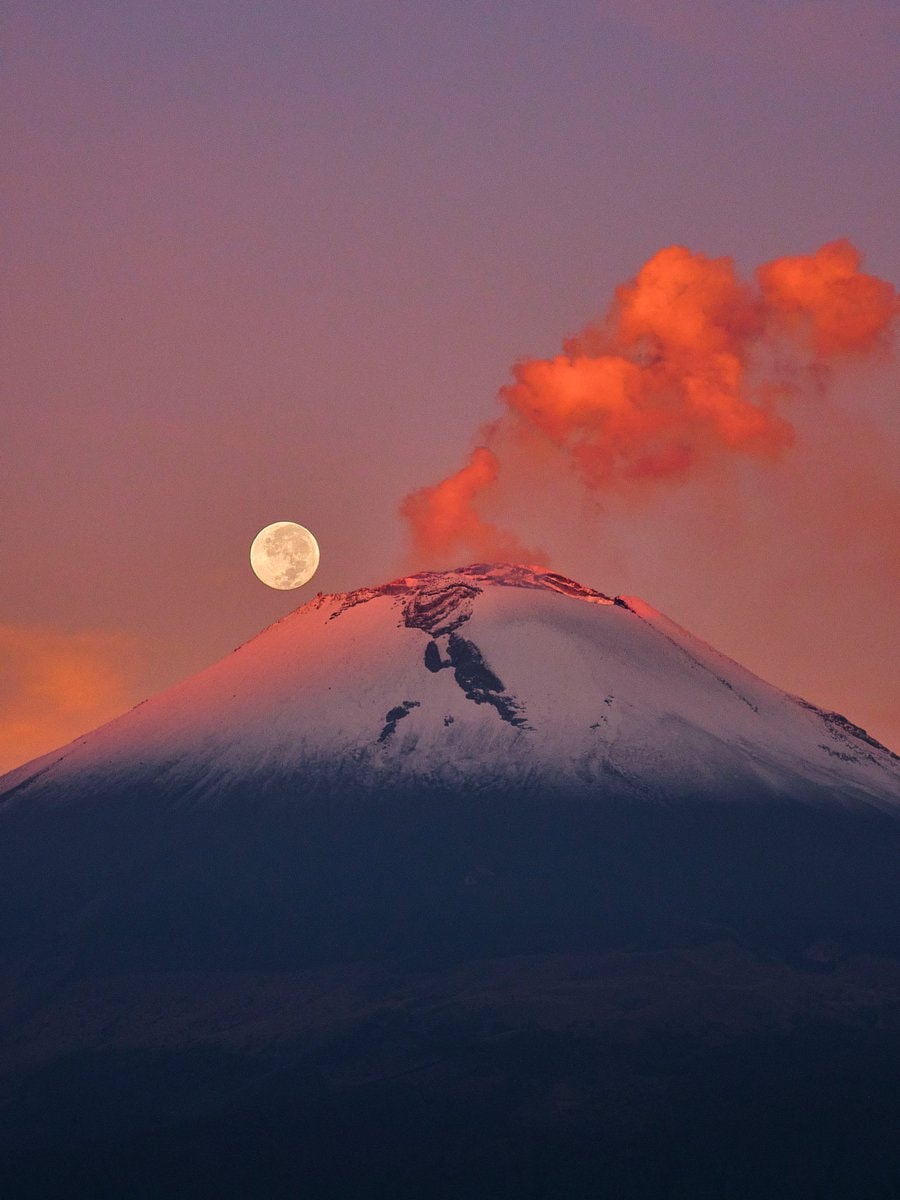 Mountain at twilight with full moon and orange clouds
