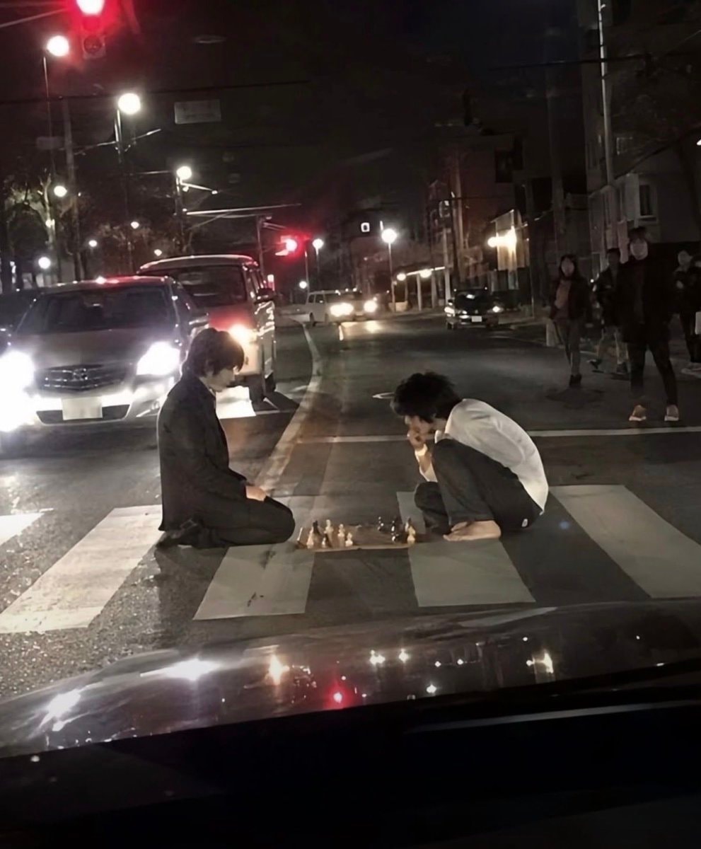 Barefoot chess on a crosswalk at night