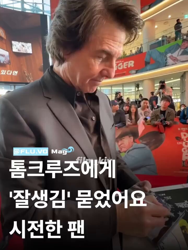 Tom Cruise signing in suit