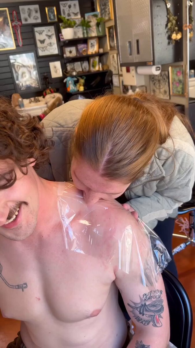 Woman kisses fresh tattoo