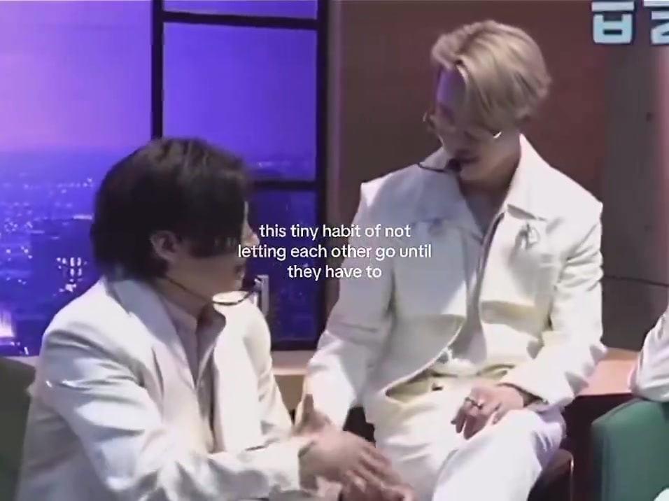 two men in white suits handshake moment