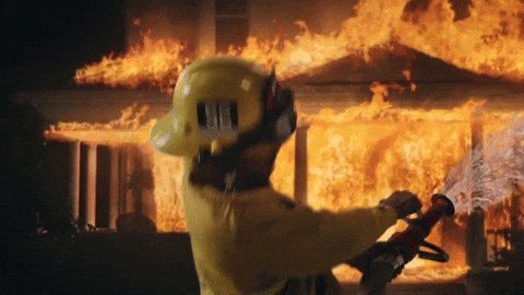 Firefighter spraying water on burning building