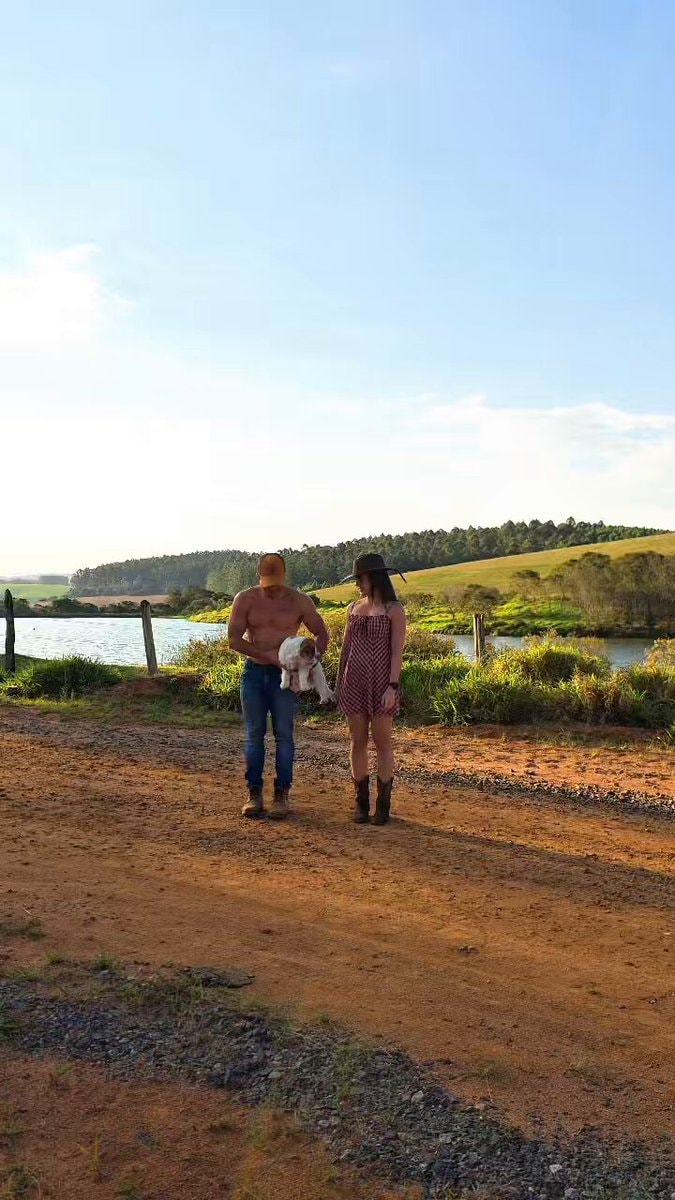 Man holding dog and woman on dirt road