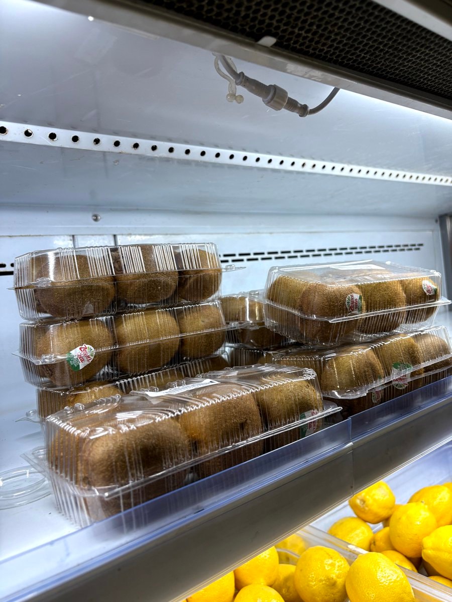 Kiwi fruit containers stacked on shelf