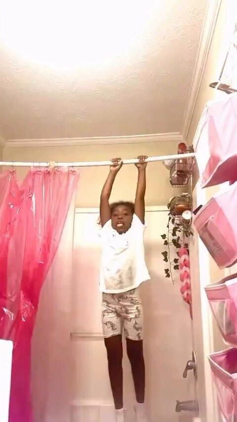 Person hanging from shower rod