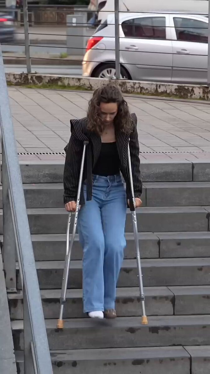 Young man carries woman on crutches