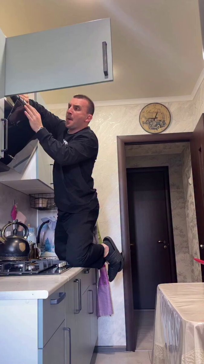guy climbs kitchen cabinet