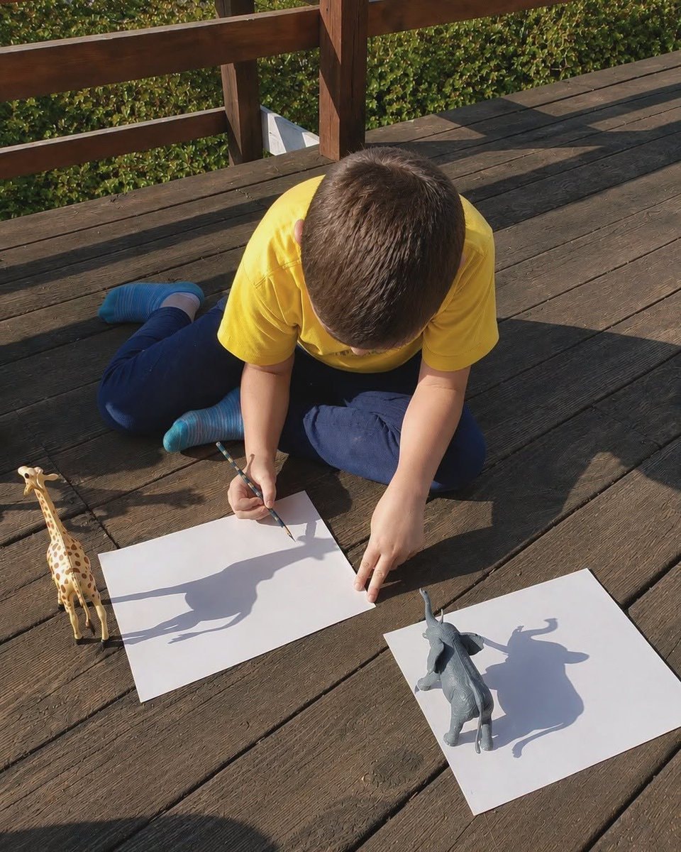 Boy drawing shadows with toys