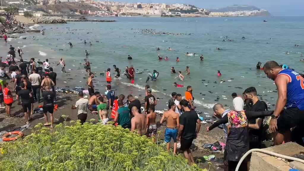 Beach littered with shoes and bags