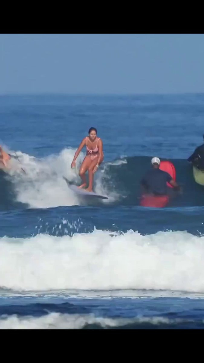 Woman in pink bikini surfing gracefully Woman in pink bikini surfing gracefully