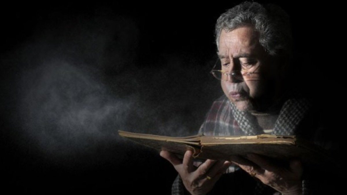 old man reading mysterious book