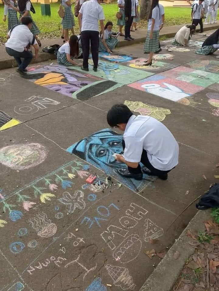 students chalk art on pavement